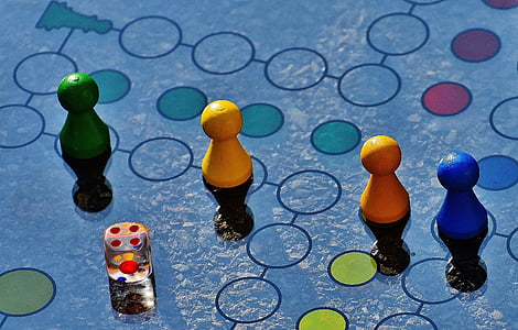 close-up photo of four game board pieces with dice thumbnail