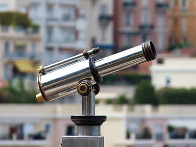person taking photo of stainless steel coin generated telescope in tilt shift photography thumbnail