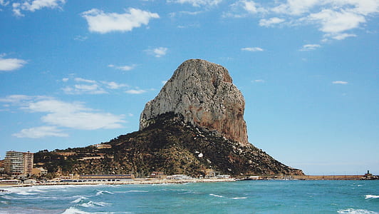 brown mountain beside body of water thumbnail