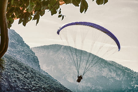 person paragliding above mountain thumbnail