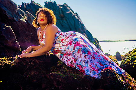 woman in multicolored floral sleeveless dress posing for photo thumbnail