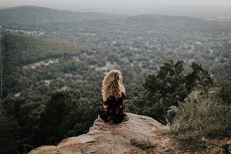 woman sitting on cliff sight-seeing trees thumbnail