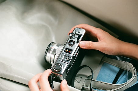 person holding silver DSLR camera thumbnail