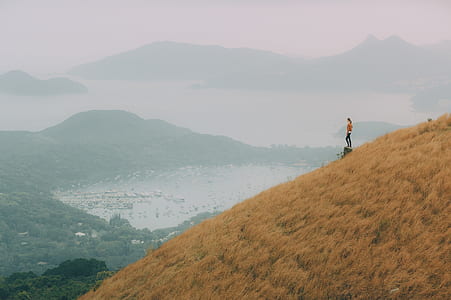 woman standing on mountain range near lake thumbnail