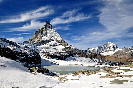 landscape photography of snow-coated mountain under cirrus clouds thumbnail