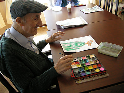 man painting in front of brown wooden table thumbnail