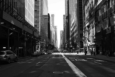 grayscale photo of buildings beside road thumbnail