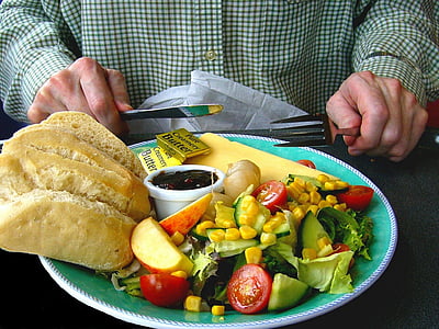 person in front of salad in plate thumbnail