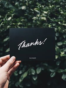 person holding black and white thanks postcard thumbnail