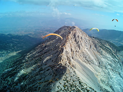 three parachutes towards mountain thumbnail