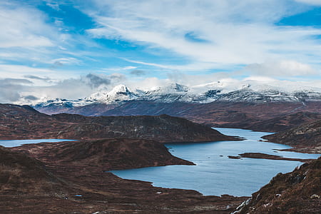 mountain surrounded by body of water thumbnail