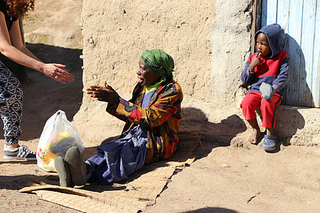 woman sitting near wall while talking to woman during daytime thumbnail