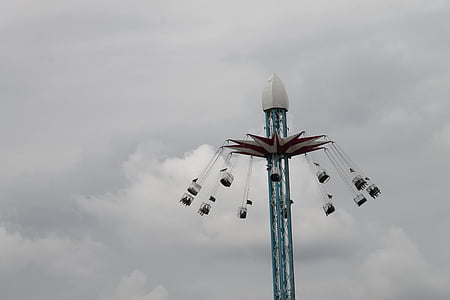 red and blue swing ride under cloudy sky thumbnail