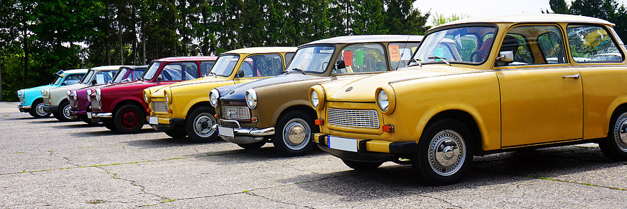 seven assorted-color parked Mini Cooper parked near trees thumbnail