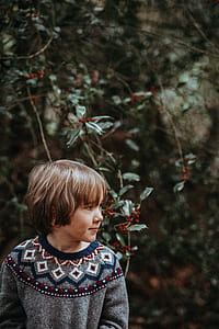 shallow focus photography of boy sitting while looking on his leftside thumbnail