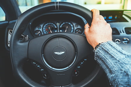 person holding Aston Martin steering wheel thumbnail
