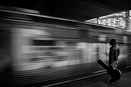 grayscale long exposure photo of man and train thumbnail