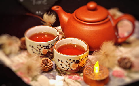 orange teapot and two white ceramic teacups thumbnail