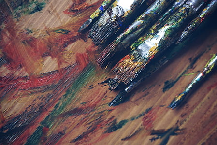 assorted-color paint brush on brown wooden table thumbnail