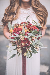Selective Focus Photography Of Bride Holding Flower Bouquet thumbnail