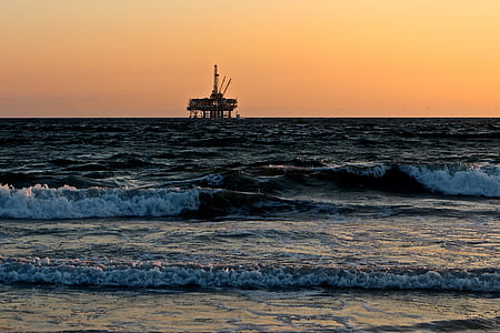 oil rig on the sea photo during sunset thumbnail