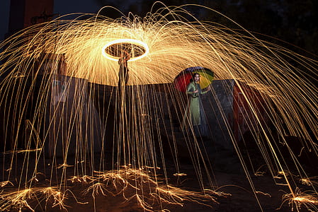 woman holding umbrella beside man steel wool photography thumbnail