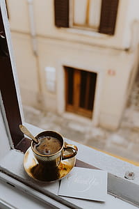 Drink coffee in a golden cup at the window thumbnail