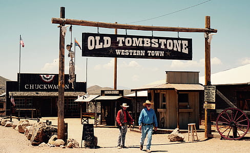 two men standing under Old Tombstone signage near house during daytime thumbnail