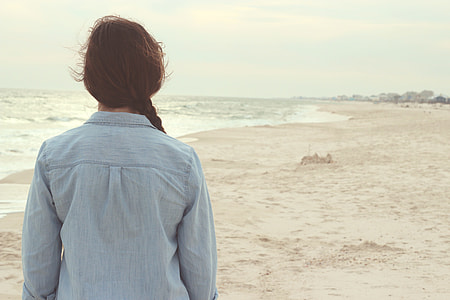 blue denim long-sleeved top near body of water during daytime thumbnail
