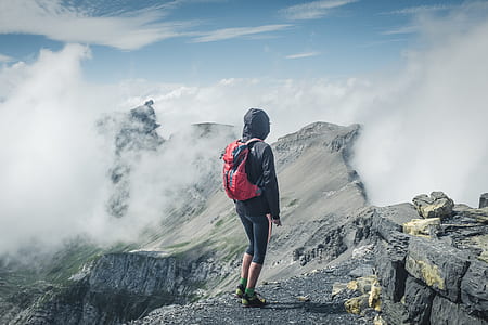 person standing on mountain filled with clouds at day time thumbnail