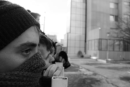 grayscale photography of people near steel barricade thumbnail