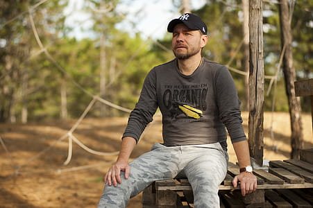 Selective Focus Photo of Man Sitting on Plank thumbnail