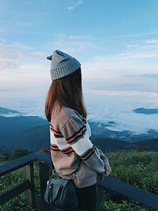 Standing Woman Wearing White and Gray Sweater thumbnail