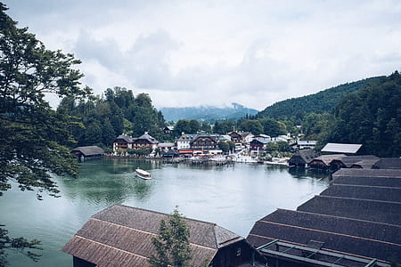 village near body of water under white sky thumbnail