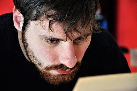 man in black top staring at white paper thumbnail