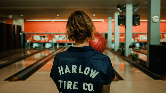 person in blue and white top holding bowling ball thumbnail