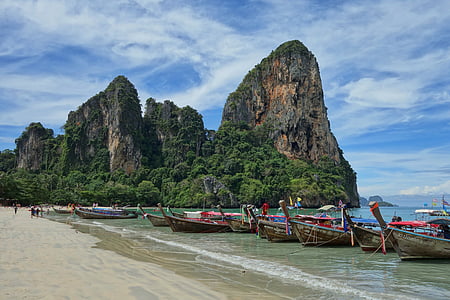 boats docked at beach near rock mountain thumbnail