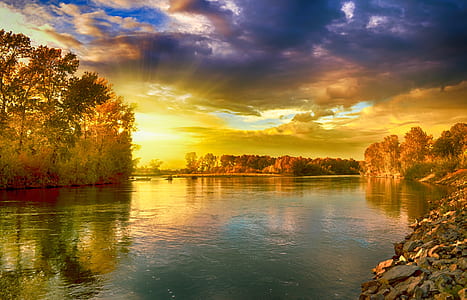 river near trees under blue and white sky during daytime thumbnail