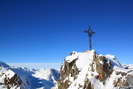 cross on top of snow covered mountain thumbnail