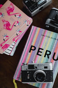 Old analog cameras and pink books on a wooden table thumbnail