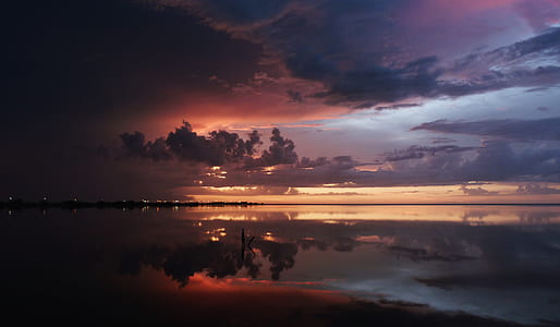 body of water over horizon during sunset thumbnail