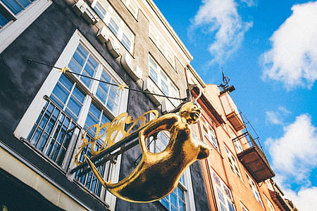 low angle photography of mermaid statue hanging from high-rise building thumbnail