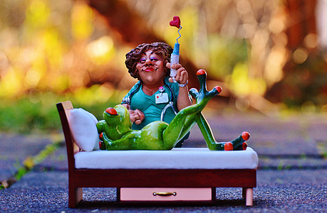 woman sitting beside frog lying figurines thumbnail