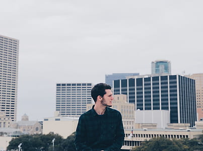 man in black dress shirt near skyscrapers thumbnail