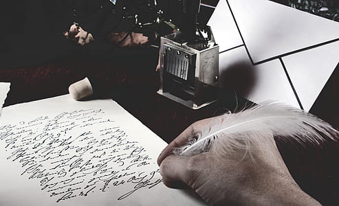 person holding feather pen thumbnail