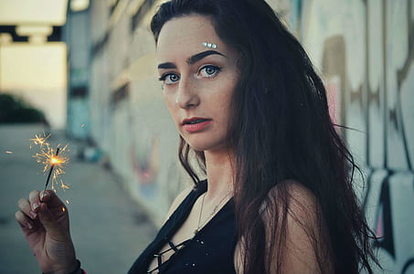 selective focus photography of woman holding sparkler thumbnail