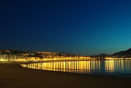lighted buildings beside body of water thumbnail