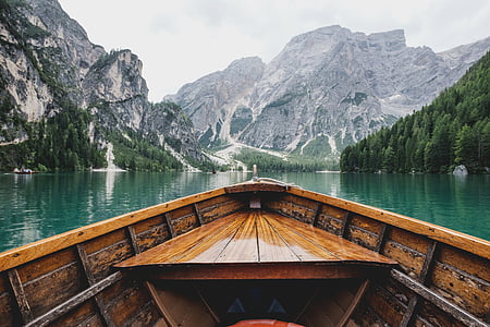 brown boat on body of water near mountains thumbnail