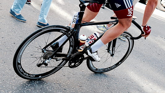 person taking photo of black road bike on road thumbnail