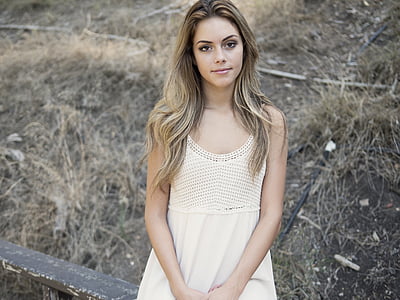 long brown haired woman wearing white sleeveless dress thumbnail